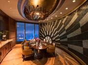 The Grill restaurant private dining room with large dining table, chairs, dining amenities, and floor-to-ceiling window with city view at night