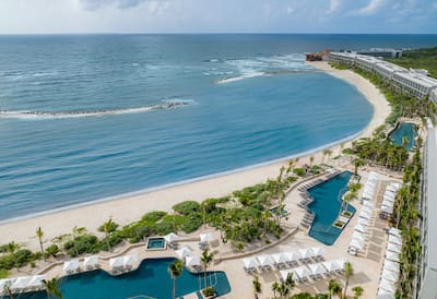 Aerial View of Hilton Tulum Hotel Exterior with Three Large Pool Areas Near the Beach