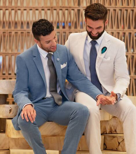 Two men in suits hold hands