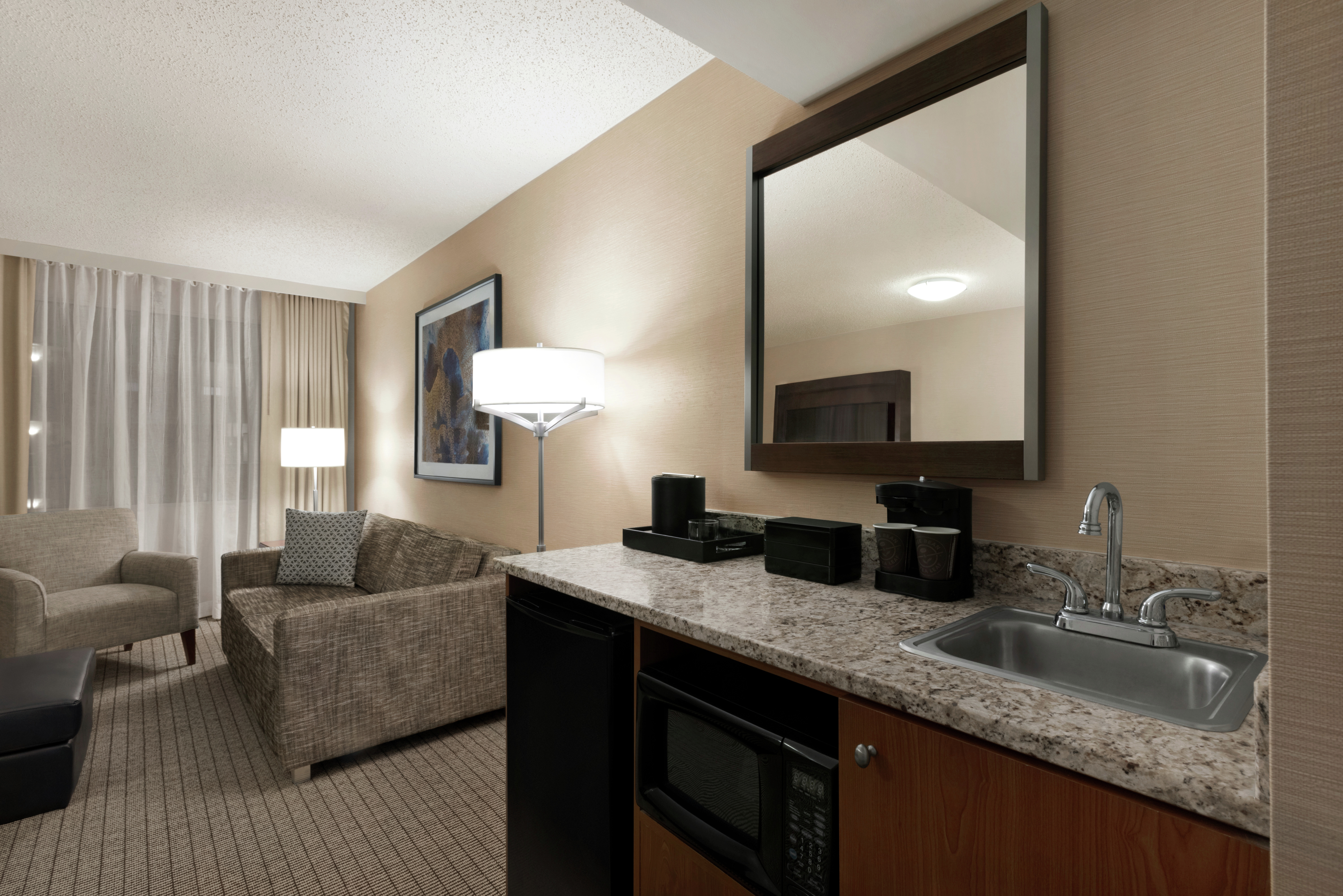 King Suite with Lounge Area, Sink, Mirror, and Room Technology