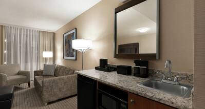 King Suite with Lounge Area, Sink, Mirror, and Room Technology