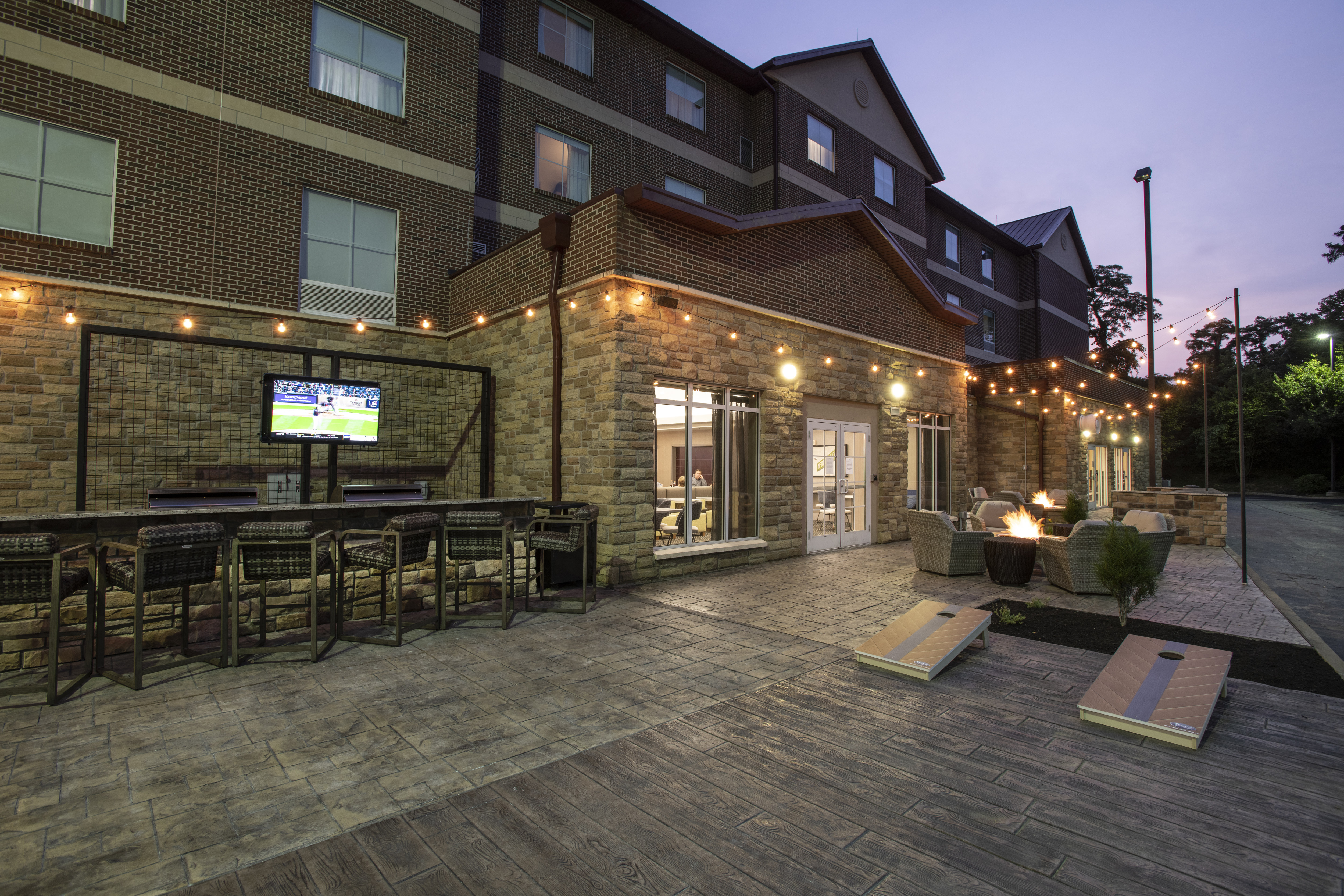 View Outdoor Patio with Fire Pit  and HDTV in the Evening