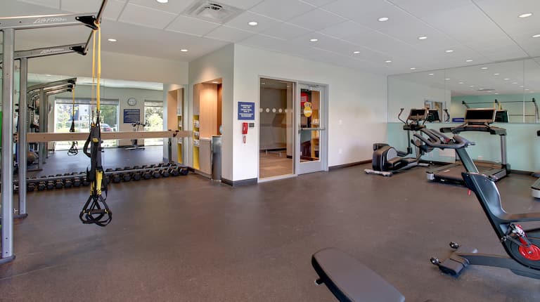 fitness room with exercise machines and weights