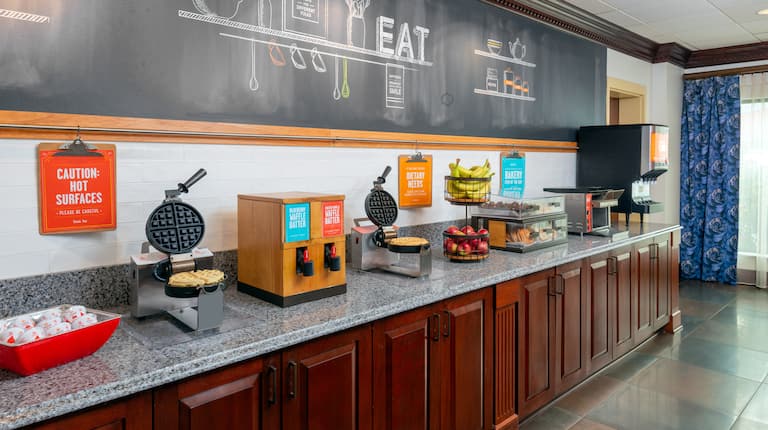 Breakfast Serving Area with Waffle Makers and Fresh Fruits