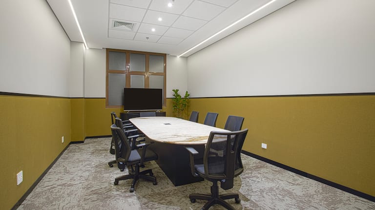 Boardroom with table and chairs and TV in room