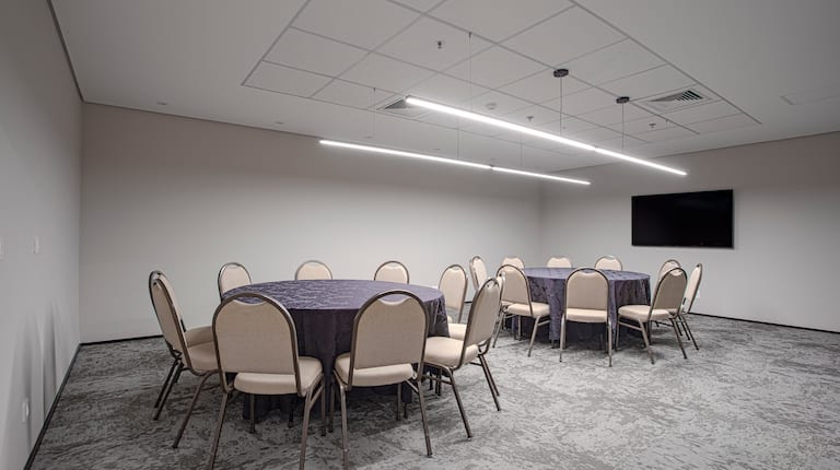 Meeting room with TV and round tables setup