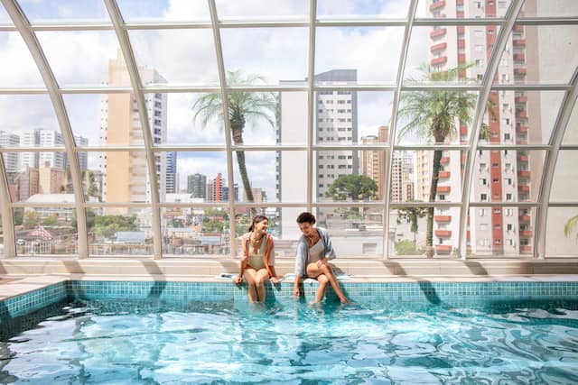 Zwei Frauen sitzen am Swimmingpool mit ihrem Futter unter Wasser