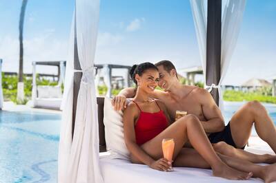 Couple in Cabana at Poolside with Cocktails