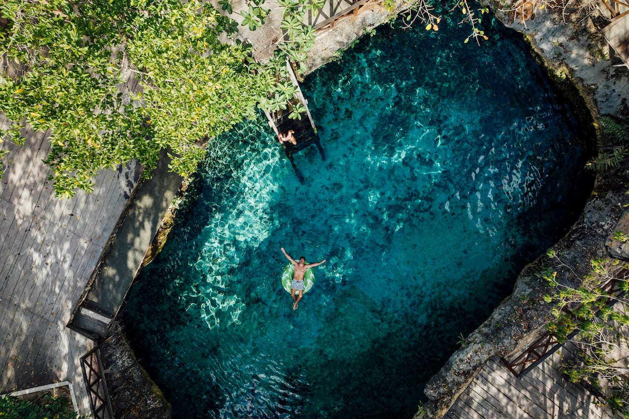 person swimming in rock pool 