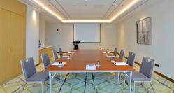 Meeting Room with Projection Screen and Seating for 8 Guests