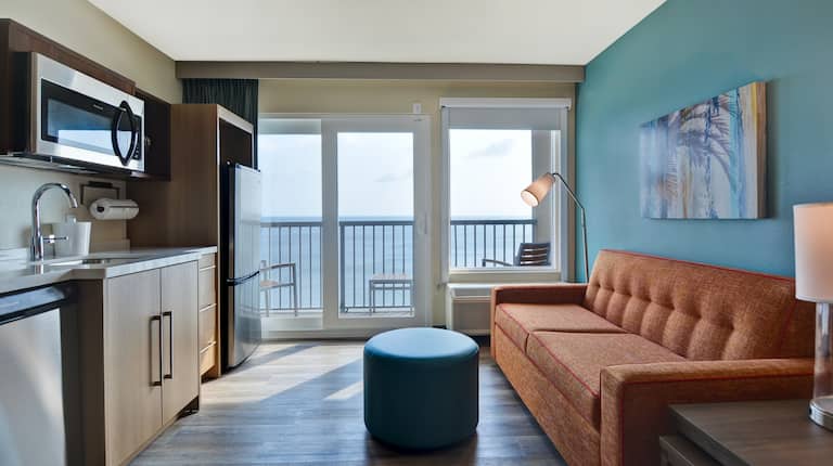 guest room lounge area showing kitchen balcony and ocean view