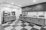 Bright hotel breakfast area with buffet counters, beverage stations, and contemporary finishes.