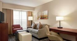 Lounge Area, TV, and Work Desk in One Queen Bedroom Suite