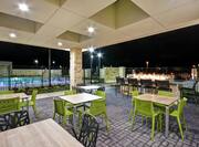 Home2 Suites Outdoor Patio with Tables, Chairs, Fire Pit, and Exterior Pool View