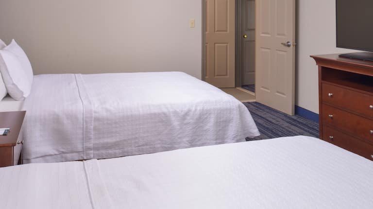 2 beds in room with TV