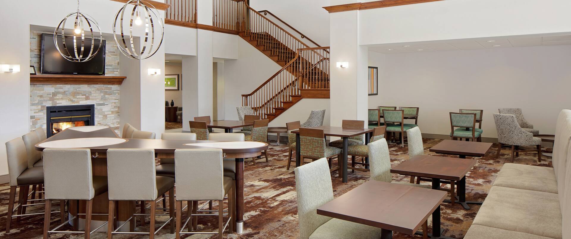 Lobby seating area with tables, chairs and fireplace