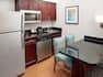 Guestroom kitchen area with cooking facilities, refrigerator and table and chairs