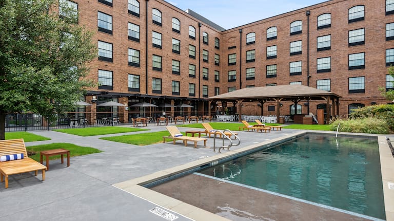 Hotel Exterior and Outdoor Pool Area with Lounge Chairs