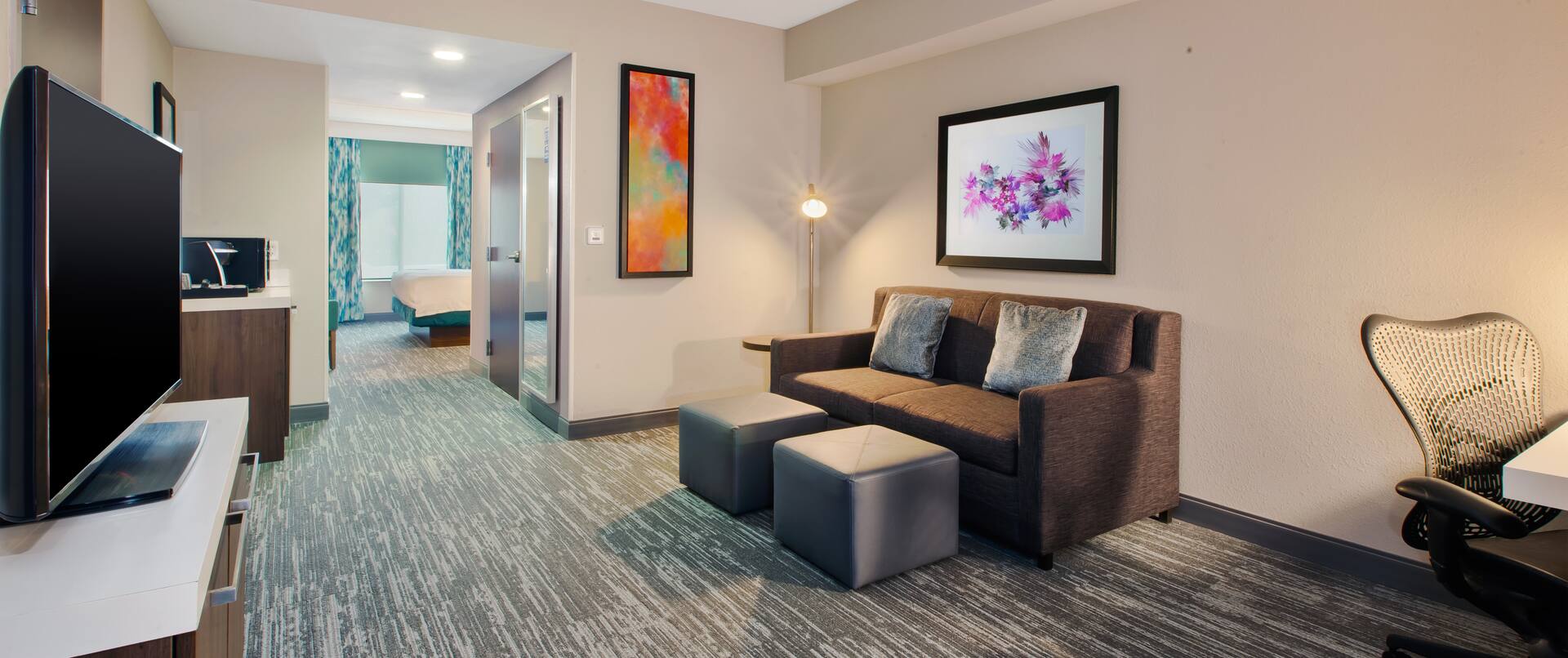 guest suite lounge area, sofa, ottomans, tv