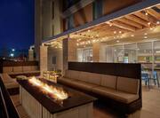 Outdoor patio area featuring comfortable soft style seating, firepit, and gazebo with string lights.