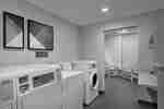 Convenient on-site coin operated guest laundry machines with folding table and seating area.