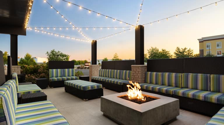 outdoor patio, seating, overhead lights, fire pit