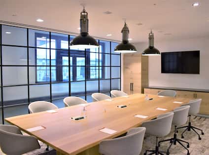 Boardroom with table, chairs and tv on wall