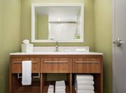 Bright guest room bathroom with vanity, mirror, and complimentary Neutrogena amenities.