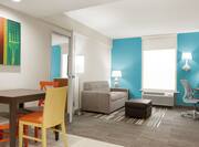 Spacious accessible suite featuring dining table, lounge area, and private bedroom.