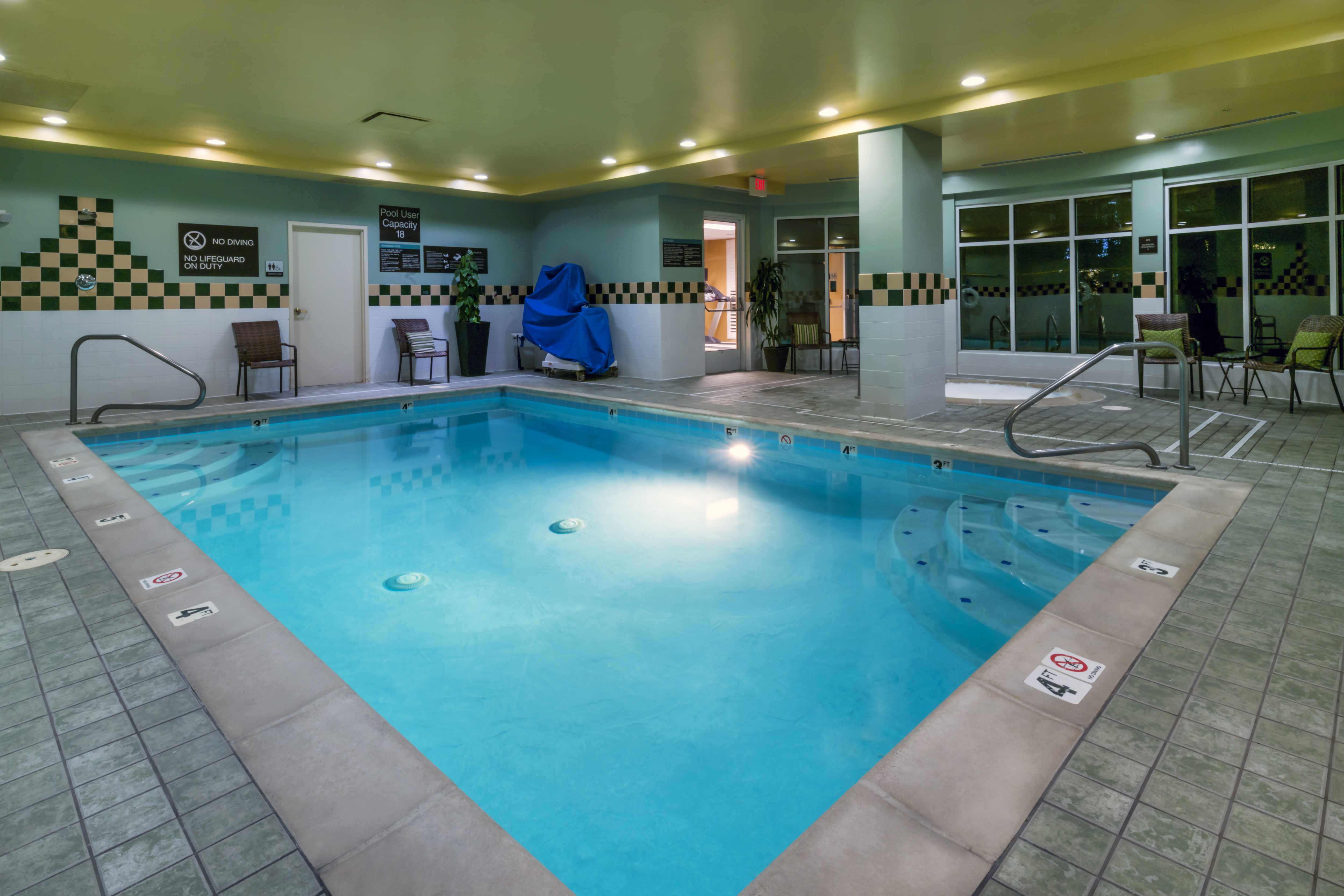 Indoor Pool with Lights in Evening With Chairs