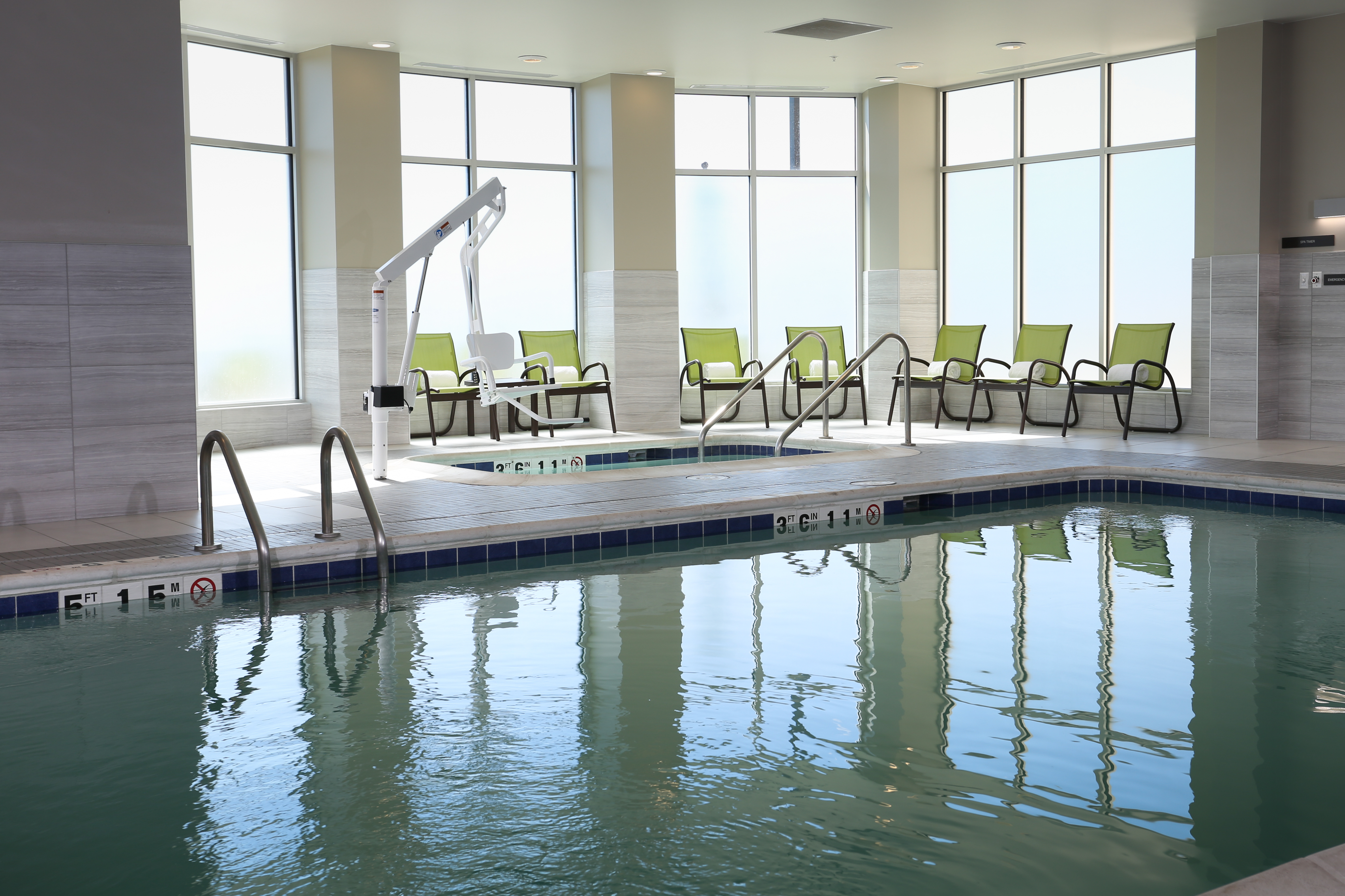 Indoor Saline Swimming Pool with Surrounding Chairs and Natural Light