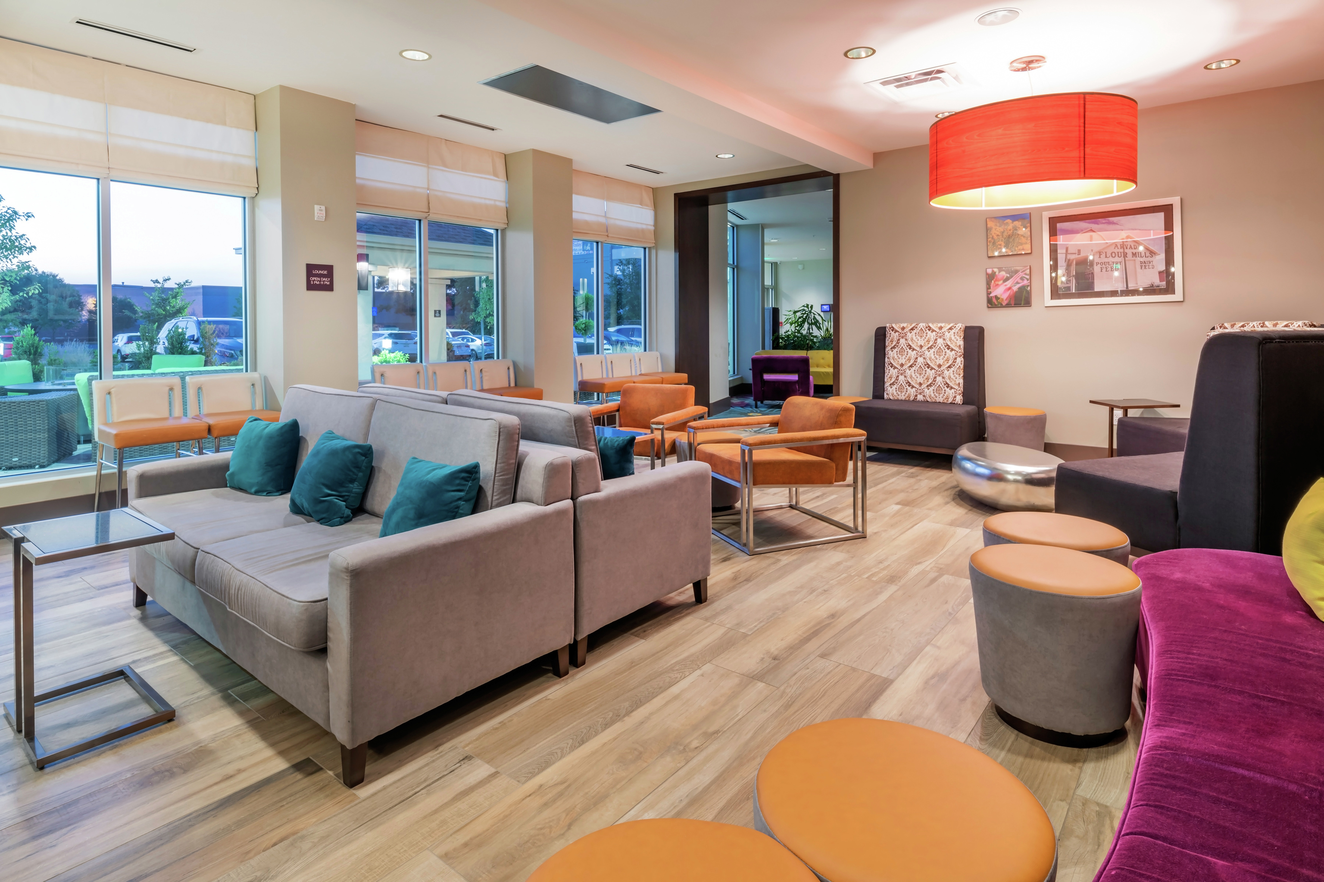 Hilton Garden Inn Lounge Area with Seats, Tables, and Outside View