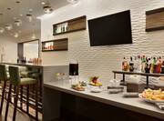 Bar Lounge Area with Bar Counter, Bar Stools and Wall Mounted HDTV