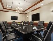 Spacious on-site boardroom featuring ample seating, large table, and TV's for presentation.