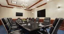 Spacious on-site boardroom featuring ample seating, large table, and TV's for presentation.