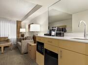 Bright guest room featuring convenient in-room wet bar and living area with comfortable seating.