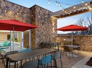 Beautiful outdoor patio off of indoor pool featuring ample seating, BBQ grill, and string lights.