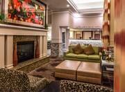 Fireplace in Lounge Area of Lobby With Colorful Art Above Mantle, Tables, and Soft Seating