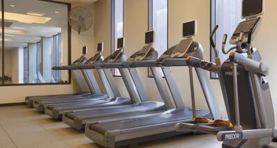 Fitness center showing treadmills and cross trainer in a light, bright environment
