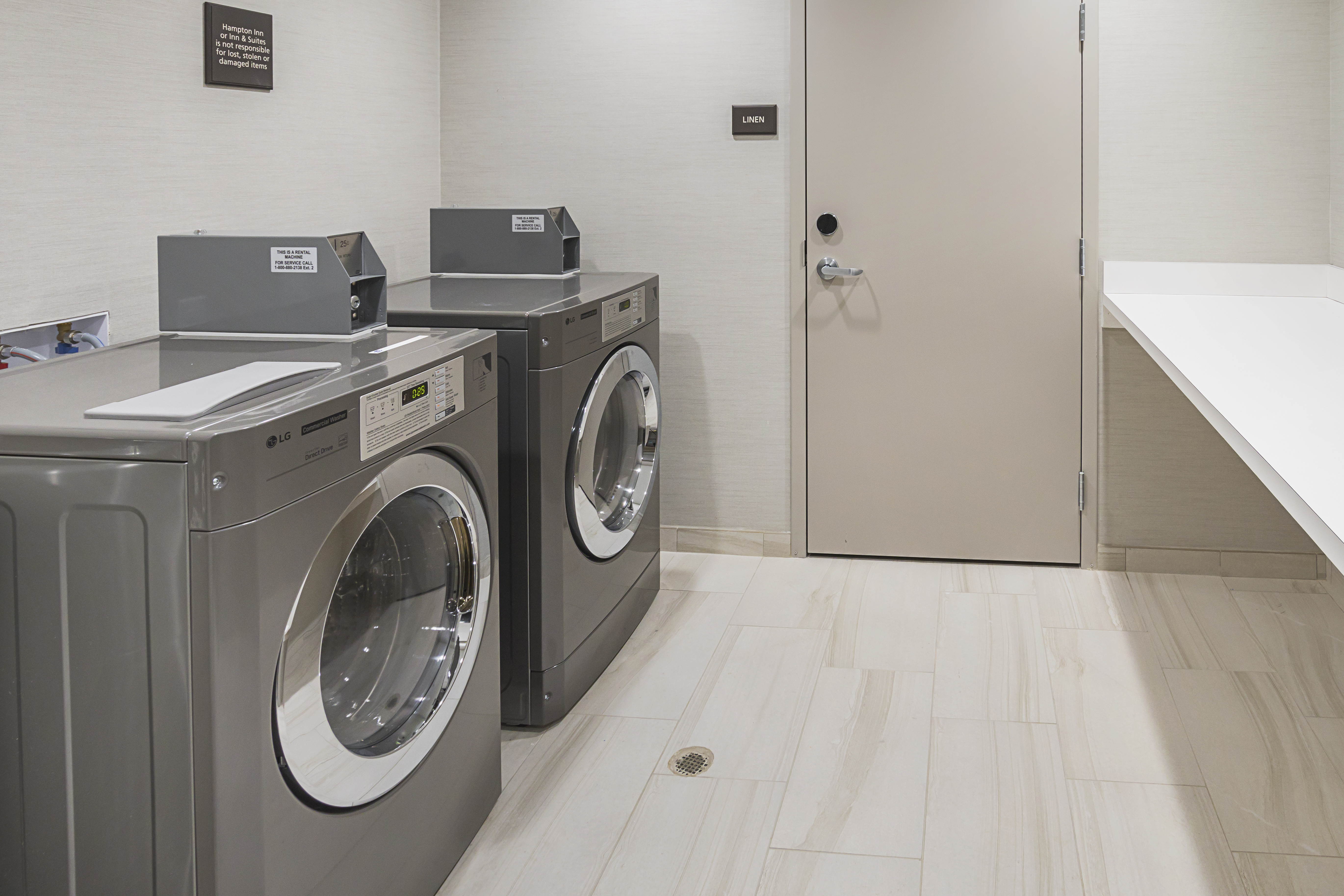 Hotel guest laundry room with
  coin-operated front load washer and dryer