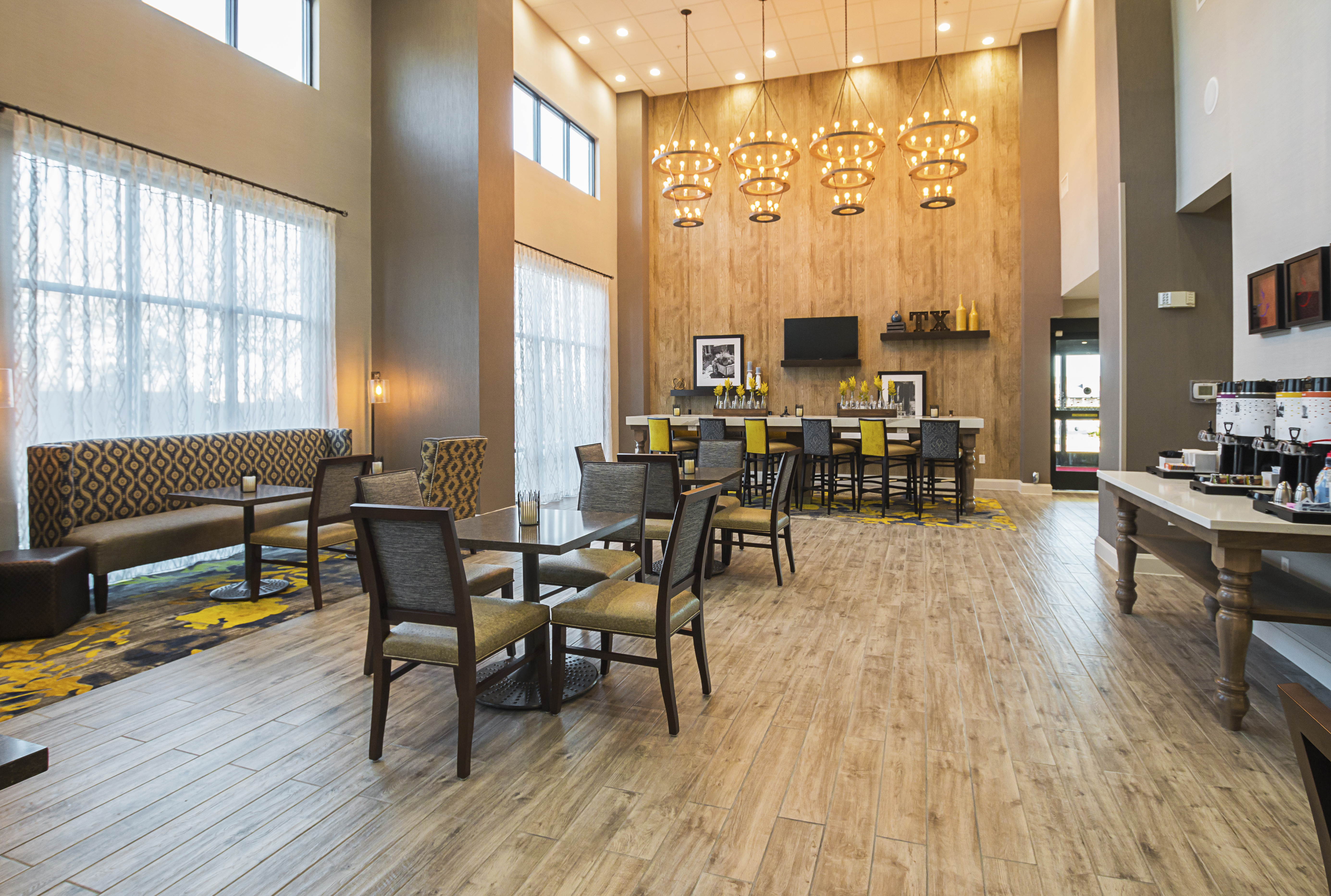 DFW hotel breakfast seating area with
  high ceilings and plenty of natural lighting