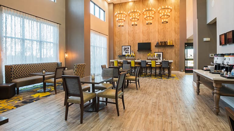 DFW hotel breakfast seating area with
  high ceilings and plenty of natural lighting