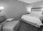 Hampton Inn Colleyville hotelkamer met kingsize bed en comfortabele chaisestoel met bijzettafel