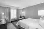 DFW-hotelkamer met kingsize bed, bureau, bureaustoel en een extra grote comfortabele chaise