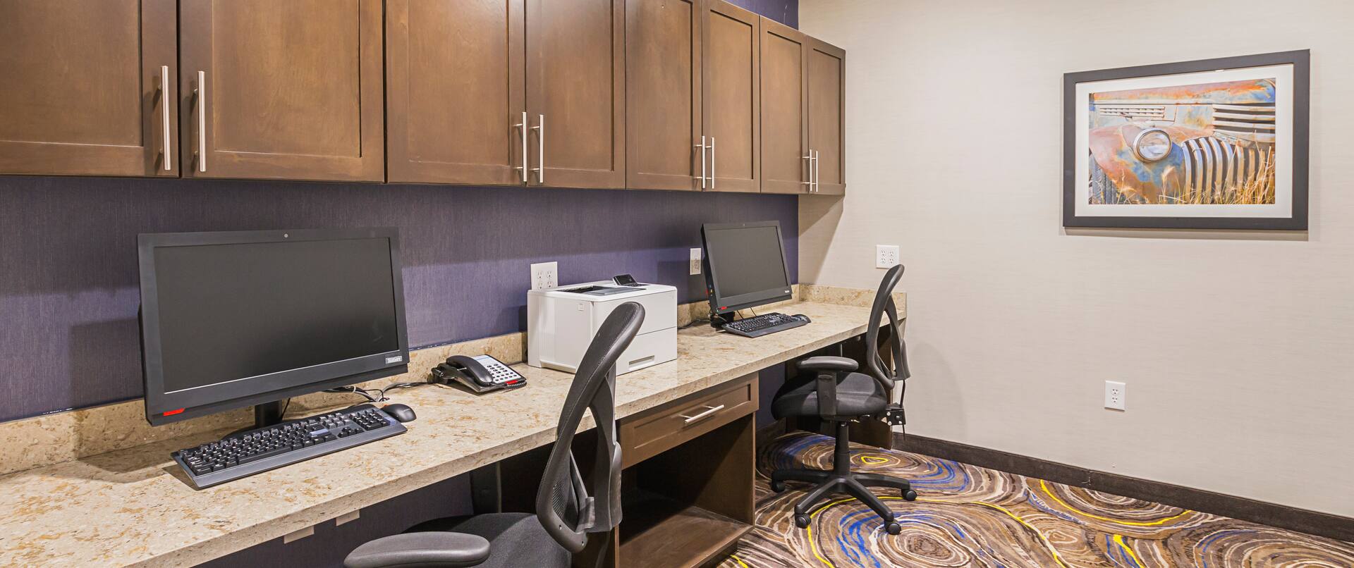 Business center with two computers, desk
  chairs, and a printer free for DFW hotel guests
