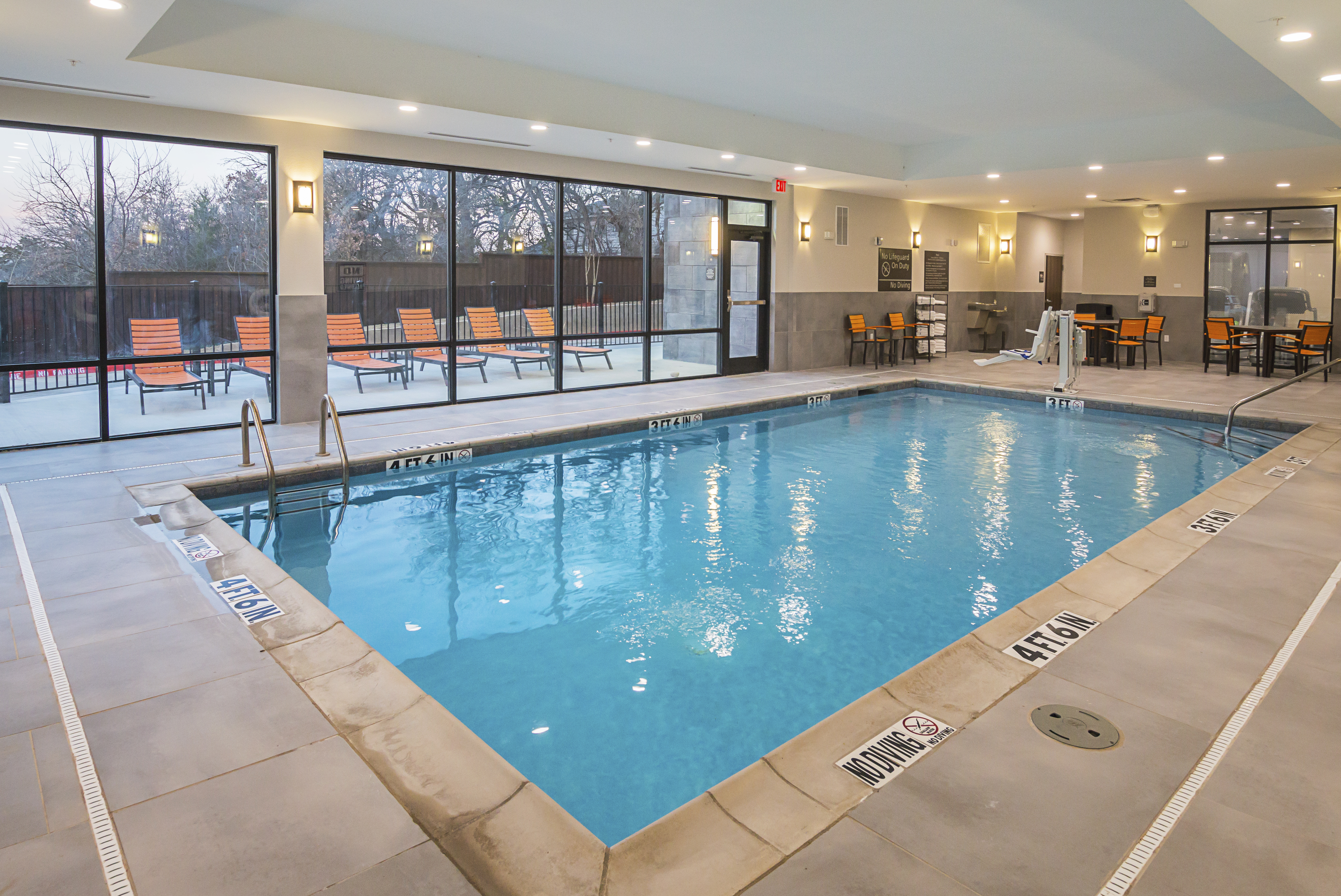 Dallas Texas airport hotel indoor pool
  with handicap accessible lift and outdoor patio with lounge chairs 
