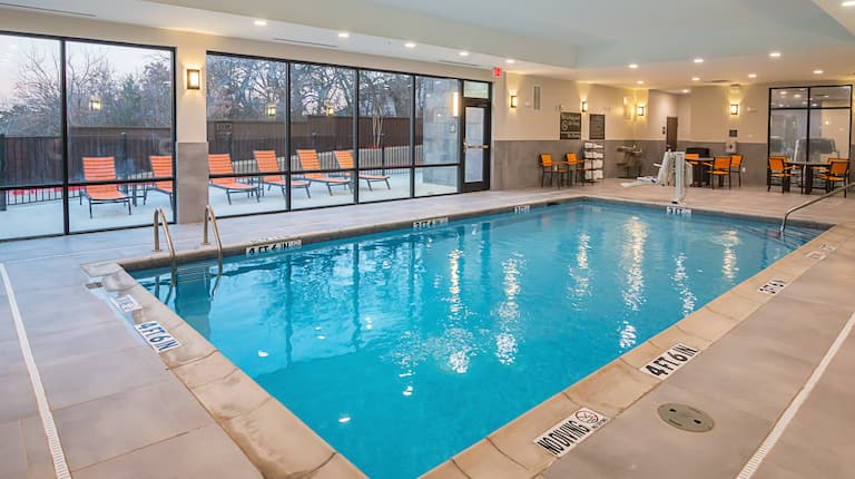 Dallas Texas airport hotel indoor pool
  with handicap accessible lift and outdoor patio with lounge chairs 
