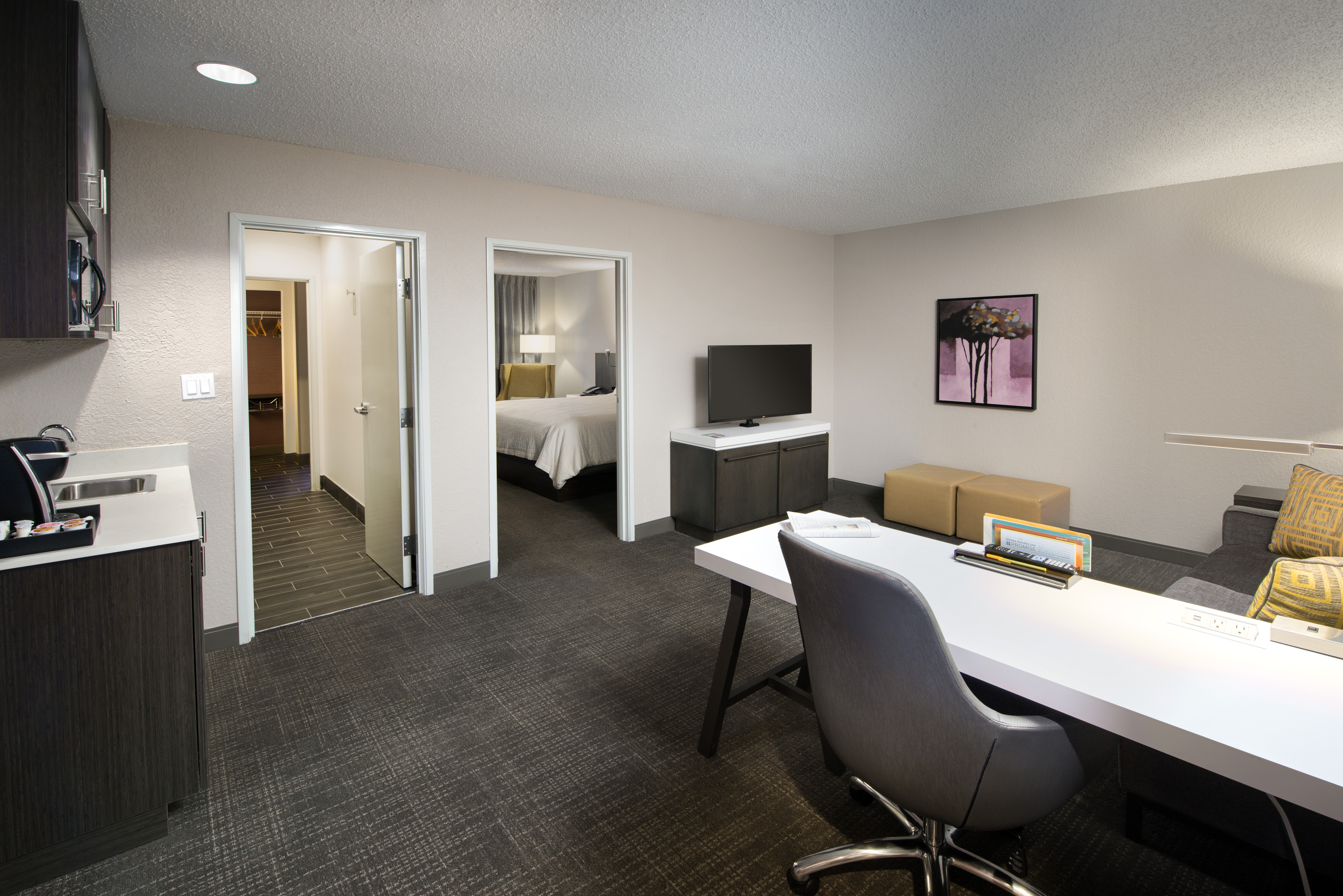 Guest Suite Lounge Area with HDTV, Work Desk, Sofa and Wetbar Area