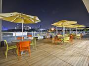 Outdoor Patio at Night with Umbrella Tables and Chairs