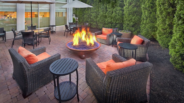 Tables With Sun Umbrellas, and Seating Around Fire Pit